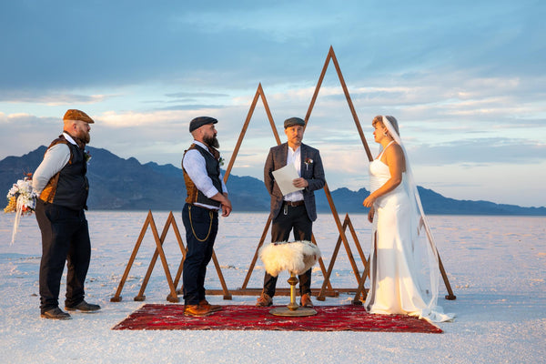 Three groomsmen in Flat Cap Revival caps at a salt flats wedding